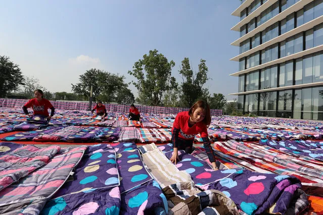 Alibaba staff dry quilts for company employees to rest in prepapration for the upcoming 11.11 global shopping festival, also called Singles' Day shopping festival, in a yard of Xixi campus of Alibaba Group in Hangzhou, Zhejiang Province, China November 3, 2016. (Photo by Reuters/Stringer)