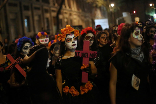 An activist with her face painted to look like popular Mexican figure “Catrina” holds a cross in a march against femicides during the Day of the Dead in Mexico City, Mexico, November 1, 2016. The cross reads; “Not one more”. (Photo by Edgard Garrido/Reuters)