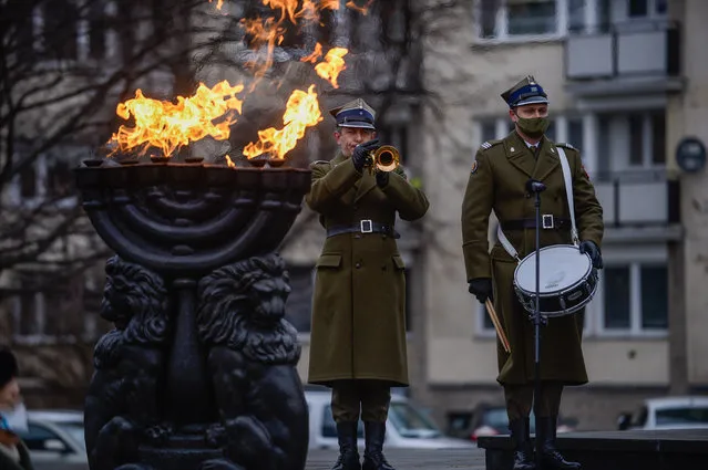 Members of the Polish Army take part in a celebration by the Monument to the Ghetto Heroes during the Holocaust Remembrance Day on January 27, 2021 in Warsaw, Poland. January 27, the day the Auschwitz concentration camp was liberated in 1945, is observed as International Holocaust Remembrance Day, although this year many memorials and educational events will be held online due to the COVID-19 pandemic. (Photo by Omar Marques/Getty Images)