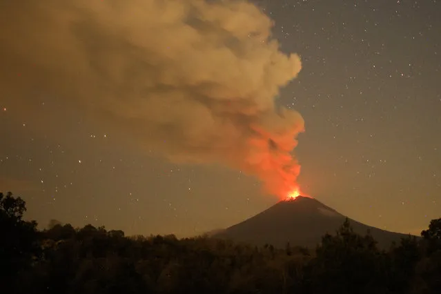 Incandescent materials, ash and smoke are spewed from the Popocatepetl volcano as seen from the San Nicolas de los Ranchos community, state of Puebla, Mexico, on May 23, 2023. Mexican authorities on May 21 raised the warning level for the Popocatepetl volcano to one step below red alert, as smoke, ash and molten rock spewed into the sky posing risks to aviation and far-flung communities below. Sunday's increased alert level – to “yellow phase three” – comes a day after two Mexico City airports temporarily halted operations due to falling ash. (Photo by Rafael Duran/AFP Photo)