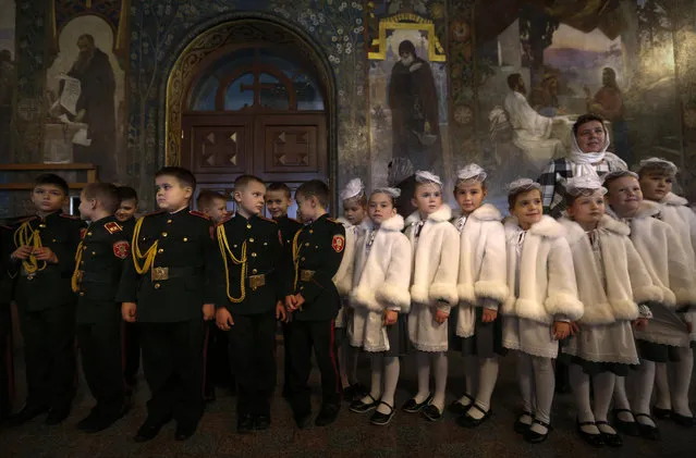Ukrainian boys and girls dressed in cadet school uniforms, attend a swear-in ceremony in the Monastery of the Caves in Kiev, Ukraine, Friday, November 11, 2016.  (Photo by Sergei Chuzavkov/AP Photo)