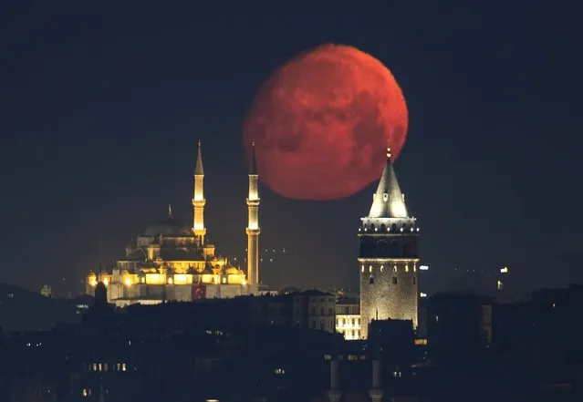 The full moon appears above Galata Tower and Fatih Mosque in Istanbul, Turkiye on June 01, 2023. (Photo by Isa Terli/Anadolu Agency via Getty Images)