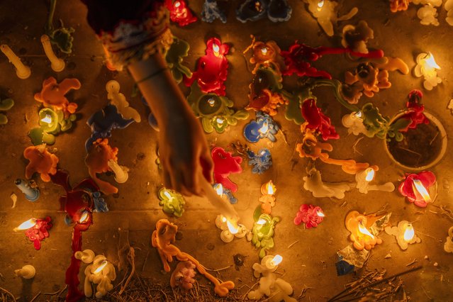 A Kashmiri Shiite Muslim girl lights a candle on the graves of her relatives, while offering prayers for the salvation of the souls of the departed, during Shab-e-Barat, on the outskirts of Srinagar, Indian controlled Kashmir, Thursday, February 13, 2025. (Photo by Dar Yasin/AP Photo)