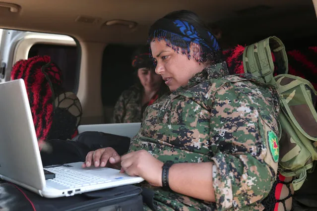 A Kurdish fighter from the People's Protection Units (YPG), operating alongside with the Syrian Democratic Forces (SDF), sits inside a vehicle as she works on a laptop in the town of Hisha after the SDF took control of the area from Islamic State militants, in the northern Raqqa countryside, Syria November 14, 2016. (Photo by Rodi Said/Reuters)