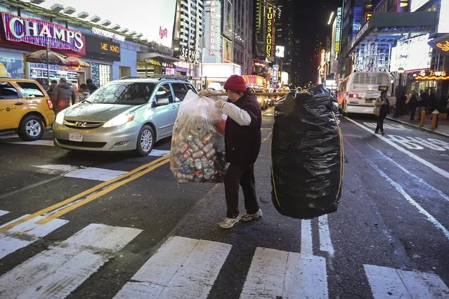 A woman who sells recyclable waste walks though Times Square with bags of full of bottles and cans in the Manhattan borough of New York November 25, 2015. (Photo by Carlo Allegri/Reuters)