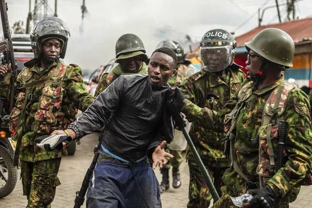 Kenyan police arrest a protester in the Kibera neighborhood of Nairobi, Kenya, Wednesday, July 12, 2023. Anti-government protesters are demonstrating in a number of Kenyan cities against newly imposed taxes and the cost of living. (Photo by Samson Otieno/AP Photo)
