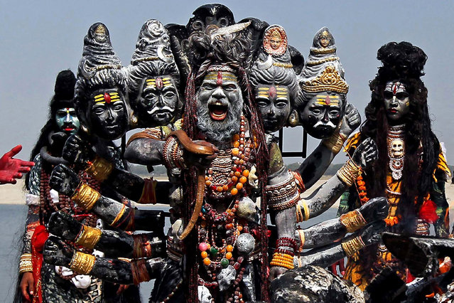 Devotees dressed as Hindu gods prepare to participate in a religious procession from a crematorium along the banks of the Ganges river in Varanasi on March 24, 2021. (Photo by Anand Singh/AFP Photo)