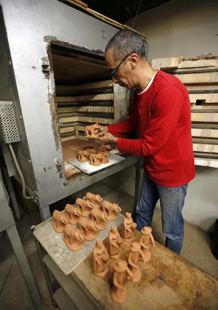 A worker places santons the typical figurines from Provence, in an oven at the Marcel Carbonel's Santon factory in Marseille, November 28, 2016. (Photo by Jean-Paul Pelissier/Reuters)