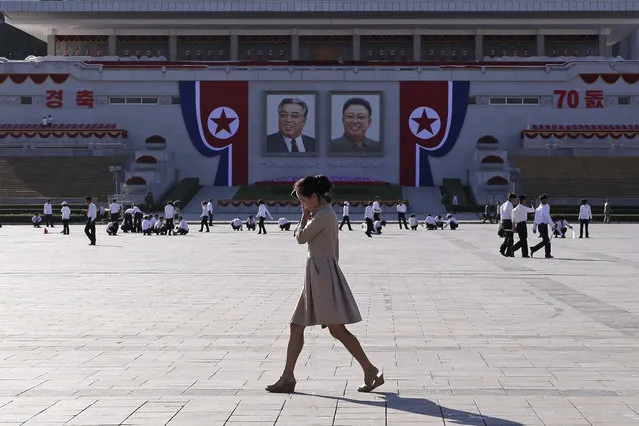 A woman walks past the preparations ongoing on Kim Il Sung Square ahead of the 70th anniversary of North Korea's founding day in Pyongyang, North Korea, Friday, September 7, 2018. (Photo by Kin Cheung/AP Photo)