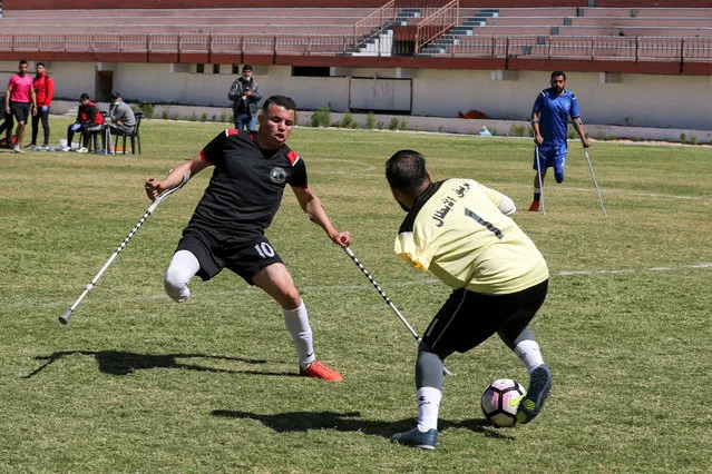A Palestinian amputee goalkeeper saves the ball during a local championship arranged by the International Committee of the Red Cross (ICRC), amid the coronavirus disease (COVID-19) outbreak, in Gaza City on March 18, 2021. (Photo by Suhaib Salem/Reuters)