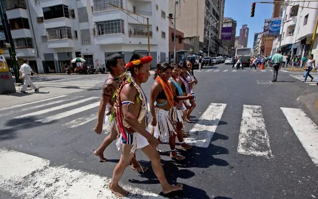 Indians in tradition garb walk away from a protest outside the General Prosecutor's office in Caracas, Venezuela, Wednesday, January 13, 2016. Dozens of Indians under the cry of "justice, justice," protested outside the General Prosecutor's office the removal of three Amazonas state elected congress members from the National Assembly. The lawmakers were barred by the Supreme Court from taking office due to alleged election irregularities. (Photo by Fernando Llano/AP Photo)