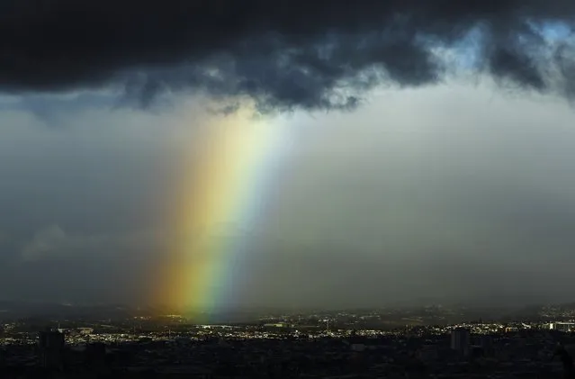 A rainbow is seen below dark clouds in San Jose city January 29, 2015. (Photo by Juan Carlos Ulate/Reuters)