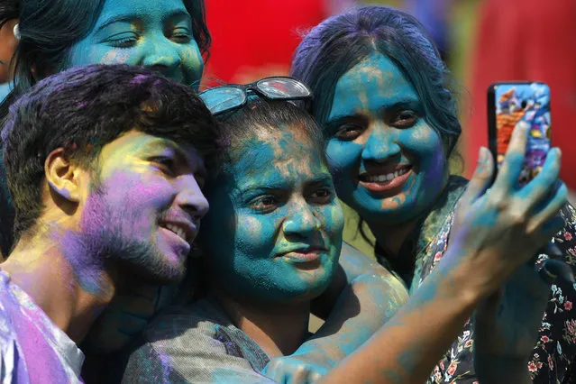 Indians, their faces smeared with colored powder, take a selfie as they celebrate Holi, the Hindu festival of colors, in Ahmadabad, India, Friday, March 6, 2015. Holi, India's joyful and colorful celebration of the arrival of spring along with several religious myths and legends, has long ago ceased to be only a Hindu festival. The streets and lanes across most of India turn into a large playground where people off all faiths throw colored powder and water at each other.(AP Photo/Ajit Solanki)