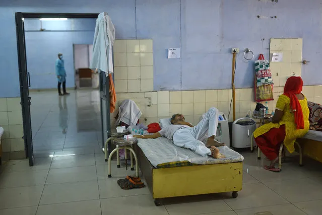 A suspected COVID-19 patient receives oxygen supply at a makeshift hospital, that was set up in a make shift hospital and where oxygen is made available for free by various Sikh religious organizations, in the outskirts of New Delhi, India, 24 May 2021. India on 24 May surpassed the barrier of 300,000 deaths from coronavirus, registering more than 4,000 deaths a day, while infections maintain a downward trend, with just over 220,000 cases in the last 24 hours. (Photo by Idrees Mohammed/EPA/EFE)