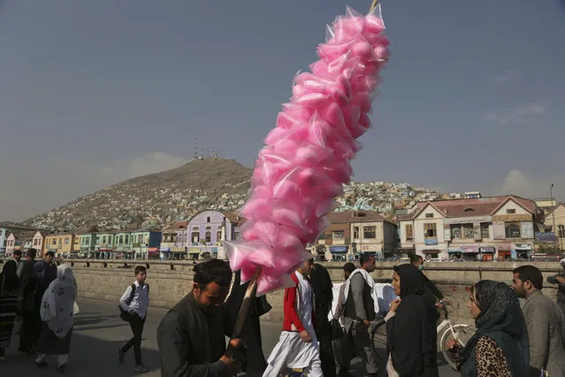 An Afghan vendor sells candy floss on a street as he waits for customers in Kabul, Afghanistan, Thursday, October 25, 2018. (Photo by Rahmat Gul/AP Photo)