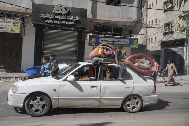 Palestinians fleeing from northern Gaza to the south with their belongings stacked on their cars after the Israeli army issued an unprecedented evacuation warning to a population of over 1 million people in northern Gaza and Gaza City to seek refuge in the south ahead of a possible Israeli ground invasion, Friday, October 13, 2023. (Photo by Hatem Moussa/AP Photo)