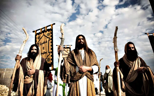 An Iranian Muslim Shiite men, acting as the prophet Jesus (C) and his apostles before the battle of Karbala, take part in the annual religious performance of “Taazieh” in the Iranian town of Noosh Abad near the central city of Kashan on November 12, 2013, marking the mourning period of Ashura which commemorates the killing of Prophet Mohammed's grandson Imam Hussein. Ashura, which climaxes on November 14, mourns the death of Imam Hussein who was killed by armies of the caliph Yazid near Karbala in 680 AD. (Photo by Behrouz Mehri/AFP Photo)