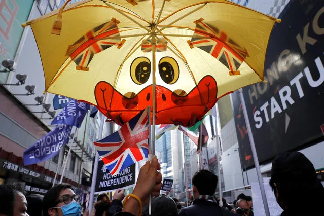 A pro-independence supporter raises an umbrella with British flags as she takes part in an annual New Year's Day march in Hong Kong, China on January 1, 2019. (Photo by Tyrone Siu/Reuters)