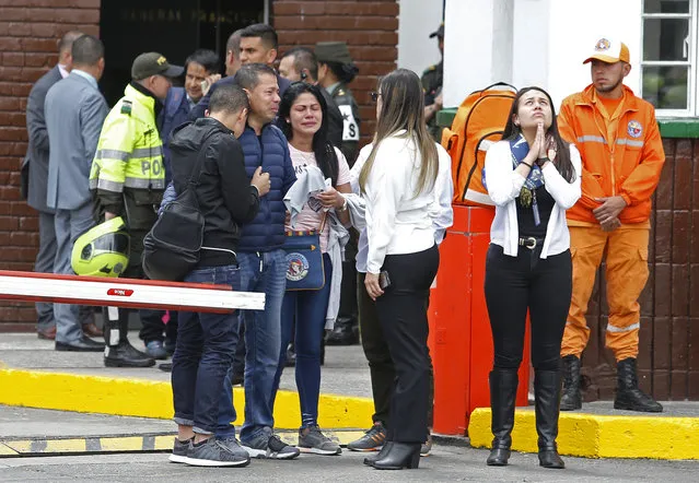 Family members of victims of a bombing gather outside the entrance to the General Santander police academy where the bombing took place in Bogota, Colombia, Thursday, January 17, 2019. (Photo by John Wilson Vizcaino/AP Photo)