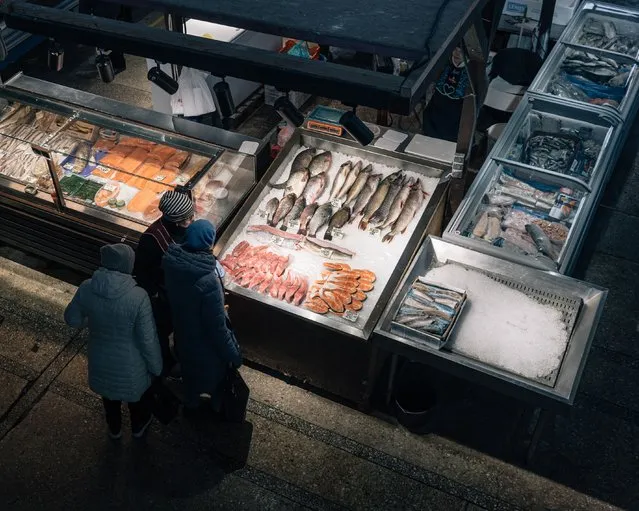 People shop for fish at a Kyiv market on November 21, 2023. (Photo by Alice Martins for The Washington Post)