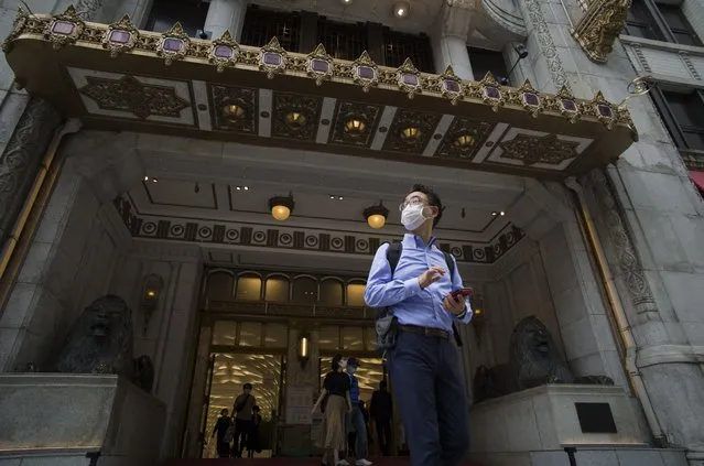 A man wearing a face mask pauses as he comes out of a department store in Tokyo during a state of emergency on Thursday, September 30, 2021. (Photo by Hiro Komae/AP Photo)