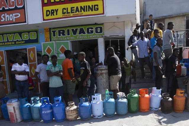 Residents line up to buy propane gas in Port-au-Prince, Haiti, Monday, February 18, 2019. Businesses and government offices slowly reopened across Haiti on Monday after more than a week of violent demonstrations over prices that have doubled for food, gas and other basic goods in recent weeks and allegations of government corruption. (Photo by Dieu Nalio Chery/AP Photo)