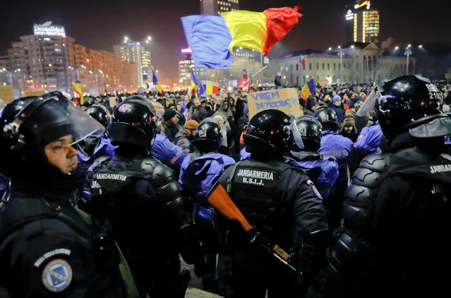 Romanian riot police protect the government building from crowds before minor clashes erupted during a protest in Bucharest, Romania, Wednesday, February 1, 2017. Brief clashes broke out between protesters and police in Romania¹s capital, as tens of thousands of people protested for the second night a government decision to decriminalise official misconduct. (Photo  by Vadim Ghirda/AP Photo)