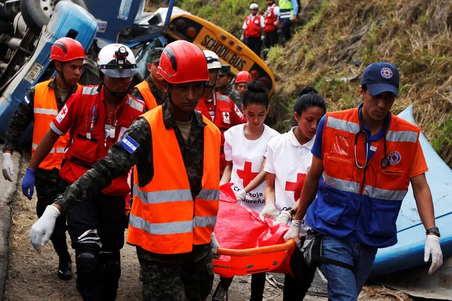 Rescue workers and members of the red cross are carrying a body after a crash between a bus and a truck on the outskirts of Tegucigalpa, Honduras, February 5, 2017. (Photo by Jorge Cabrera/Reuters)