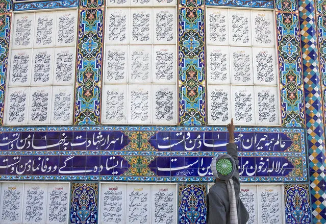 An Afghan veteran and a staff member of the museum points out the names of Afghans who were killed during their fight against Russia in 1979, in Herat, on November 5, 2009. (Photo by Morteza Nikoubazl/Reuters)