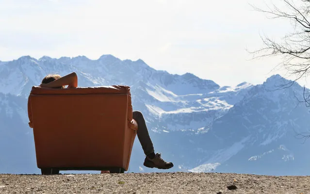 A hiker takes a rest in an armchair near the Hochbichl alpine hut near Ofterschwang, southern Germany, on March 21, 2014. (Photo by Karl-Josef Hildenbrand/AFP Photo/DPA)