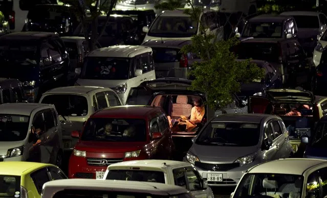 Evacuees who have been using their vehicles for shelter at a parking lot after a series of earthquakes, spend the night inside their cars in Kumamoto, Japan, in this photo taken by Kyodo April 20, 2016. (Photo by Reuters/Kyodo News)