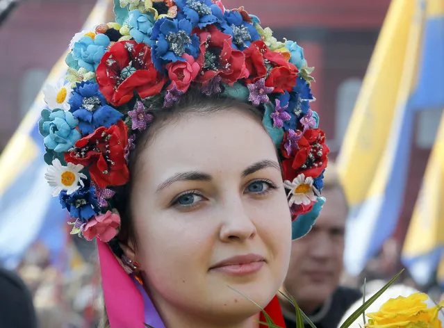 A Ukrainian, dressed in traditional embroidered clothing attends an event at a monument to the revered national poet Taras Shevchenko marking the 203th anniversary of his birth,  in Kiev, Thursday, March 9, 2017. (Photo by Efrem Lukatsky/AP Photo)