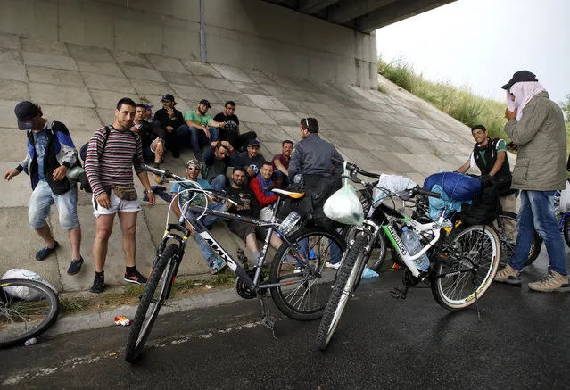 A group of migrants from Syria and Iraq rest under an express road underpass the shelter from the rain, near Petrovec, some 20 kms (12 miles) east of Skopje, Macedonia, Wednesday, June 17, 2015. Macedonia has become one of the main transit routes for thousands of migrants from the Middle East and Africa who enter the European Union in Greece from Turkey and then make their way overland on foot or bicycle to the more prosperous northern countries. (AP Photo/Boris Grdanoski)