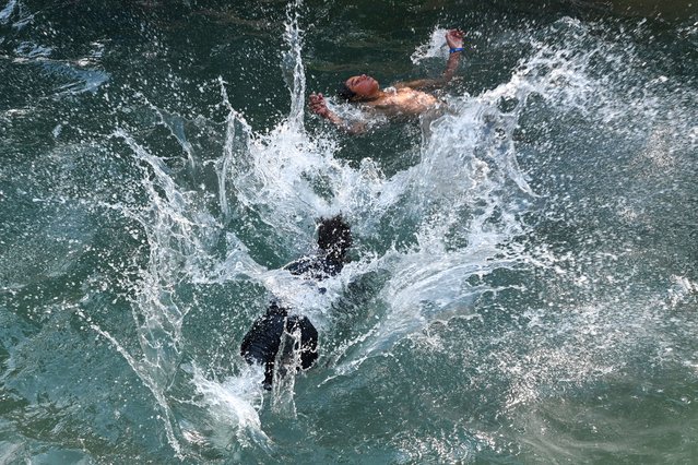 Boys cool themselves in a pool on a hot summer day in Lahore on May 7, 2024. (Photo by Arif Ali/AFP Photo)