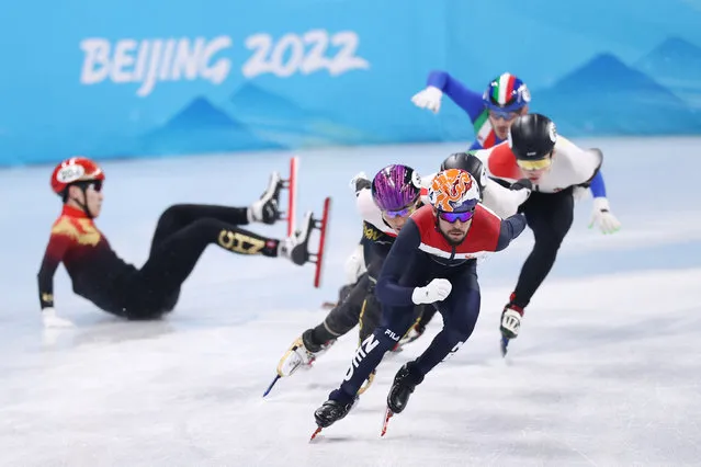 Sjinkie Knegt of Team Netherlands and Kazuki Yoshinaga of Team Japan compete as Tianyi Zhang of Team China falls during the Men's 1500m Quarterfinals on day five of the Beijing 2022 Winter Olympic Games at Capital Indoor Stadium on February 09, 2022 in Beijing, China. (Photo by Dean Mouhtaropoulos/Getty Images)