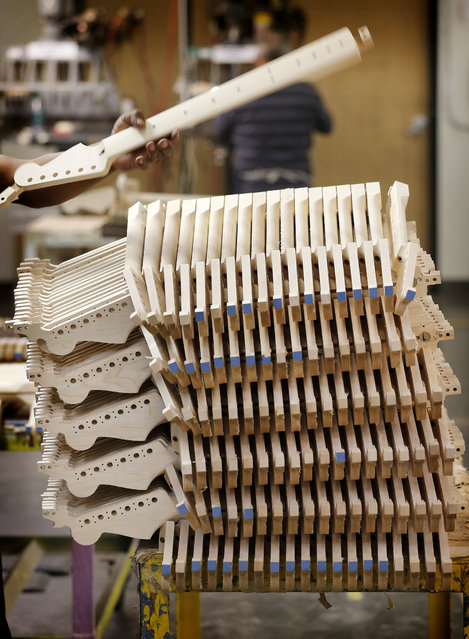 Fender Stratocaster electric guitar necks are prepared for assembly at the Fender factory in Corona, Calif. Leo Fender developed the instrument in a small workshop in Fullerton, Calif. six decades ago. (Photo by Matt York/AP Photo)
