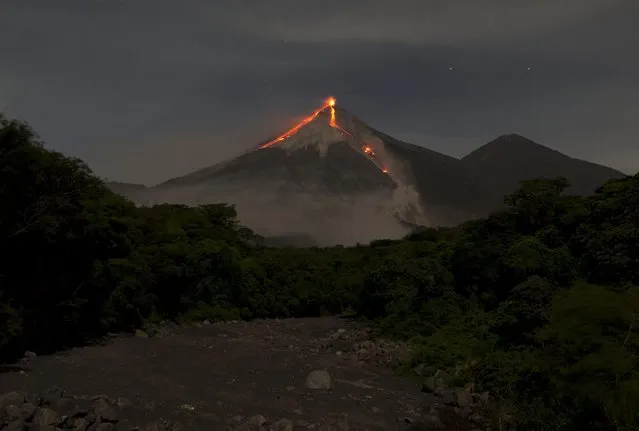 In this image taken with a long exposure, the Volcan de Fuego, or Volcano of Fire, spews hot molten lava from its crater in San Juan Alotenango, Guatemala, Wednesday, July 1, 2015. The Guatemalan emergency agency CONRED raised the alert level in the area after the volcano restarted its activity on early Wednesday. (Photo by Moises Castillo/AP Photo)