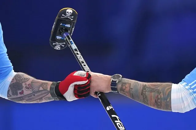 United States' Matt Hamilton, left, and Christopher Plys celebrate after a good throw during the men's curling bronze medal match between Canada and the United States at the Beijing Winter Olympics Friday, February 18, 2022, in Beijing. (Photo by Brynn Anderson/AP Photo)