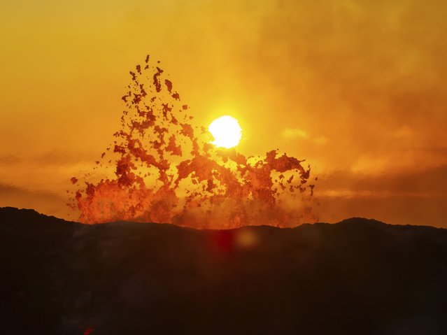 The sun rises above the active crater of the volcano near Grindavik, Iceland, Monday, June 10, 2024. A volcano in southwestern Iceland has been erupting spewing red lava close to the coastal town of Grindavik. (Photo by Marco di Marco/AP Photo)