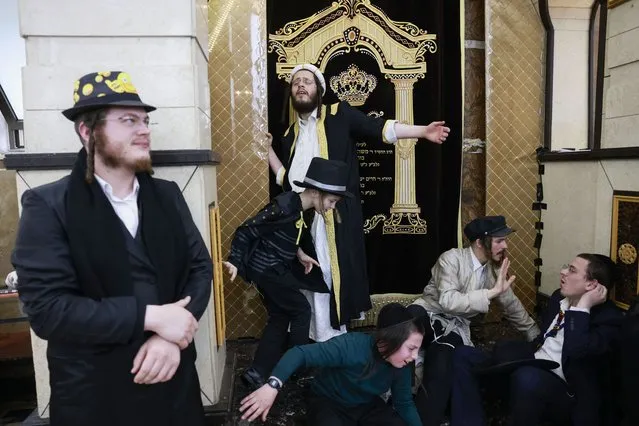 Jewish men and youths in Purim costumes celebrate in the Mea Shearim ultra-Orthodox neighbourhood in Jerusalem, on March 18, 2022. The carnival-like Purim holiday is celebrated with parades and costume parties to commemorate the deliverance of the Jewish people from a plot to exterminate them in the ancient Persian empire 2,500 years ago, as recorded in the Biblical Book of Esther. (Photo by Menahem Kahana/AFP Photo)