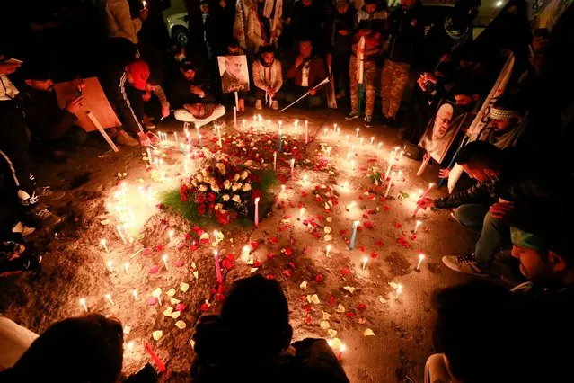 Iraqis light candles during a commemoration ceremony held to mark the upcoming second anniversary of the killing of Iranian general Qasem Soleimani and his Iraqi lieutenant Abu Mahdi al-Muhandis (image), at the spot where they were killed, near Baghdad's International Airport, on January 2, 2022. The January 3, strike against Soleimani, the architect of Iran's Middle Eastern military strategy, was ordered by then US president Donald Trump, and it also killed his Iraqi lieutenant Abu Mahdi al-Muhandis, the Hashed's deputy chief. (Photo by Ahmad Al-Rubaye/AFP Photo)