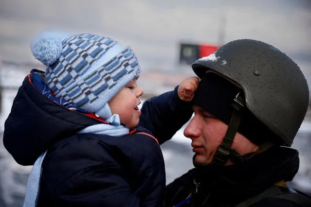 A police officer says goodbye to his son as his family flees from advancing Russian troops as Russia's attack on Ukraine continues in the town of Irpin outside Kyiv, Ukraine, March 8, 2022. (Photo by Thomas Peter/Reuters)