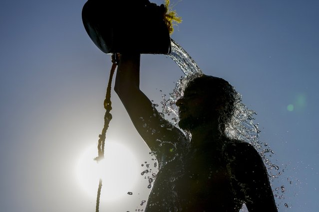 A man rinses with fresh water after playing beach volley ball on a sweltering hot day, at the Ramlet al-Baida public beach in Beirut, Lebanon, Tuesday, July 16, 2024. (Photo by Hassan Ammar/AP Photo)