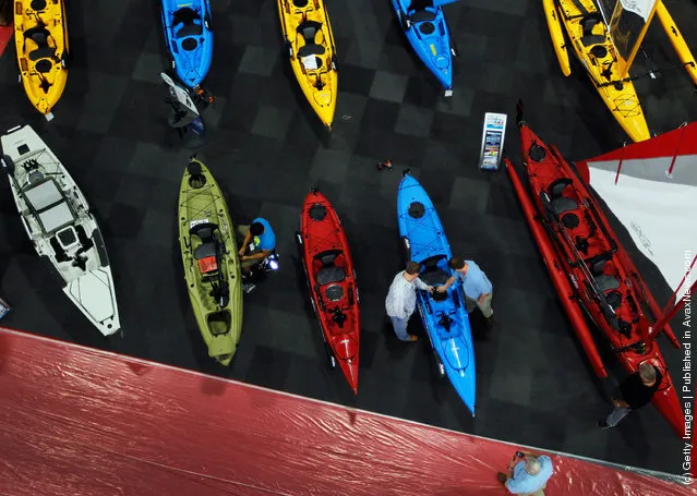 Workers prepare boats for tomorrow's opening day of the four day long Progressive Insurance Miami International Boat Show at the Miami Beach Convention Center