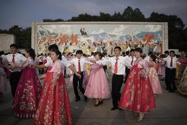 Students participate in a mass dance in front of a mural of the late North Korean leader Kim Il Sung delivering a speech, Monday, July 27, 2015, in Pyongyang, North Korea as part of celebrations for the 62nd anniversary of the armistice that ended the Korean War. (Photo by Wong Maye-E/AP Photo)
