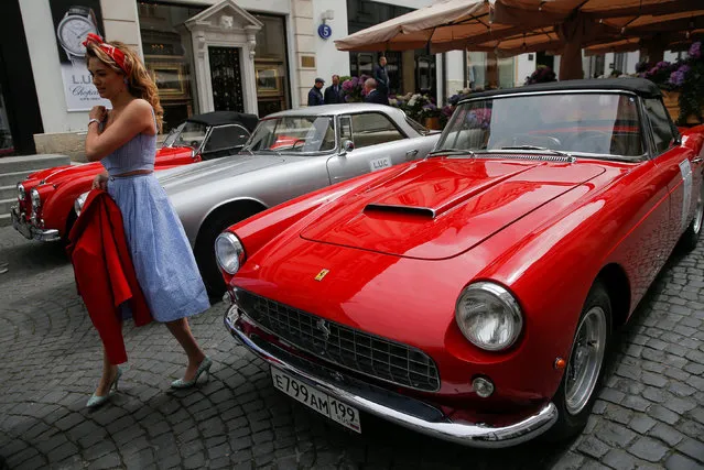 A woman passes a Ferrari classic car before the start of the annual L.U.C Chopard Classic Weekend Rally 2017 in central Moscow, Russia May 4, 2017. (Photo by Maxim Shemetov/Reuters)
