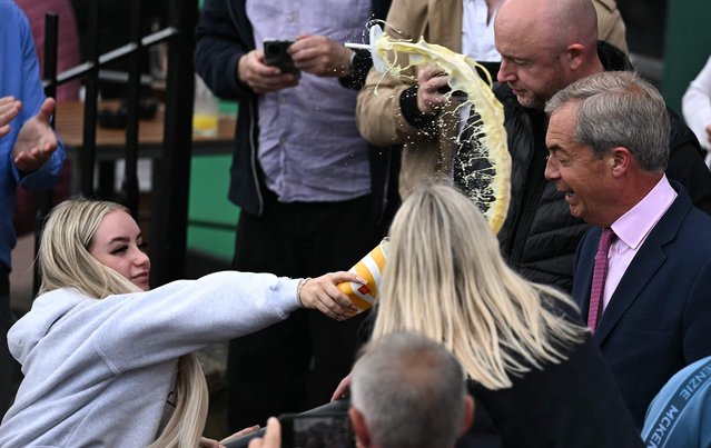 A person throws the contents of a drinks cup in the face of newly appointed leader of Britain's right-wing populist party, Reform UK, and the party's parliamentary candidate for Clacton, Nigel Farage, during his general election campaign launch in Clacton-on-Sea, eastern England, on June 4, 2024. Nigel Farage on Monday said he would stand as a candidate for the anti-immigration Reform UK party in Britain's general election next month, after initially ruling out running. “I have changed my mind... I am going to stand”, Farage, 60, told a news conference. He will seek election on July 4 in the fiercely pro-Brexit seat of Clacton, southeast England. (Photo by Ben Stansall/AFP Photo)