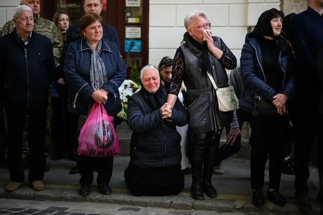 Galina Malets (C) drops to her knees as she sees the coffin of her borther ahead of the funeral service for fallen soldier Igor Malets, aged 59, at the Saints Peter and Paul Garrison Church on May 05, 2022 in Lviv, Ukraine. Igor Malets was wounded on April 27 in Izyum and died in hospital in Dnipro on April 30. The Ukrainian government has not released recent figures on military casualties since Russia's Feb. 24 invasion vary widely, but estimates suggest they are significantly outpaced by Russian losses. (Photo by Leon Neal/Getty Images)