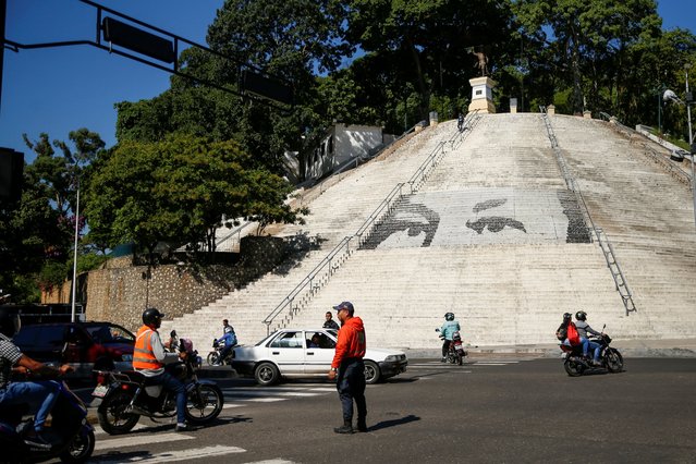 A member of the traffic brigade of the Bolivarian National Police controls vehicular traffic during a power outage affecting Caracas and other regions of the country, in Caracas, Venezuela on August 30, 2024. (Photo by Leonardo Fernandez Viloria/Reuters)