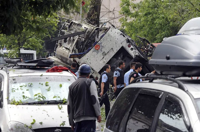 Turkish security officials and firefighters work at the explosion site after a bus carrying riot police official was struck by a bomb in Istanbul, Tuesday, June 7, 2016. At least five police officers were wounded. The blast occurred at a busy intersection near an Istanbul University building in the city's Beyazit district during the morning rush hour. (Photo by DHA via AP Photo)